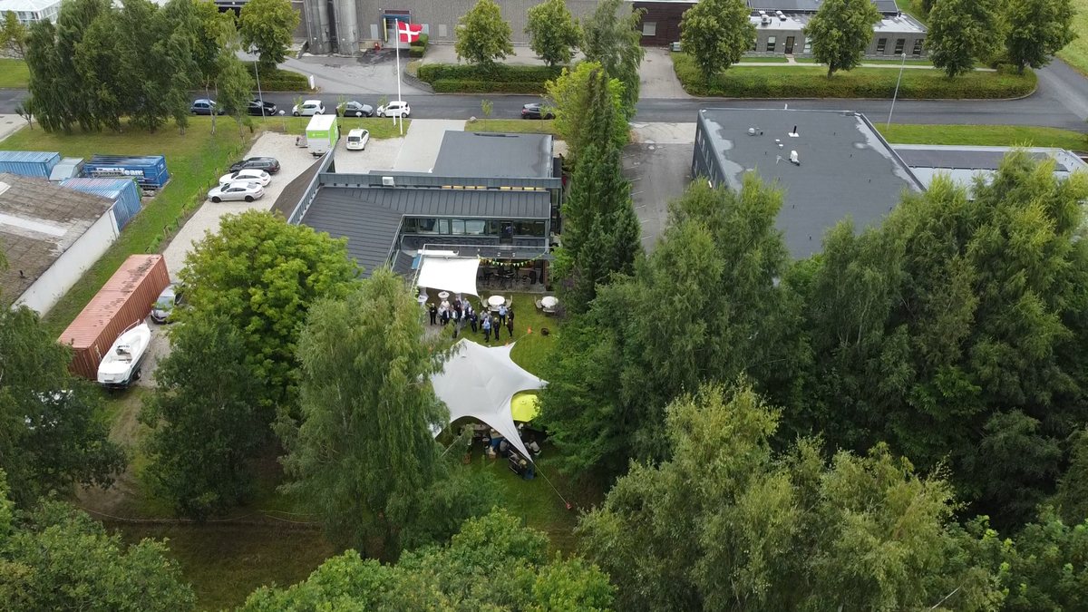 Luftfoto af CKE's have med et stort hvidt telt og samlede gæster